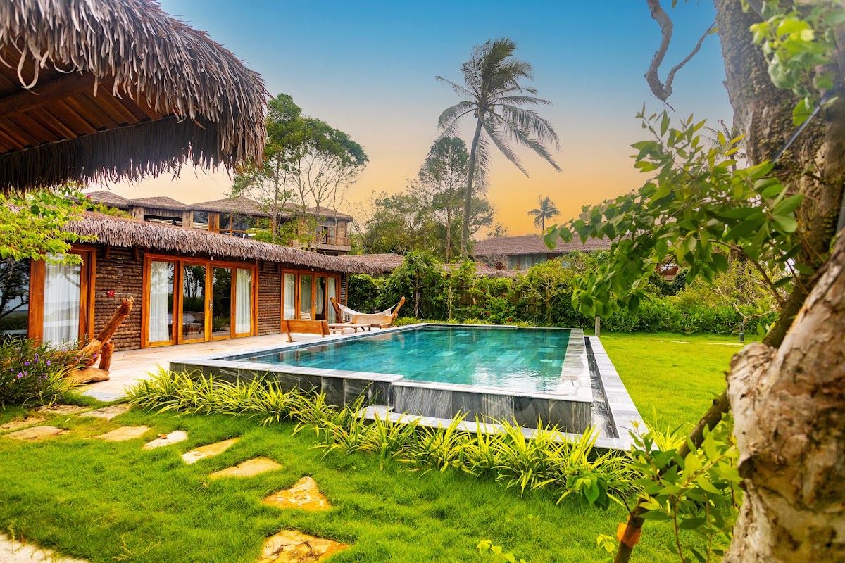 A pool-facing bungalow at a resort on Ong Lang — the format most properties here follow Tropical resort pool with bungalows surrounded by palm trees at Ong Lang, Phu Quoc
