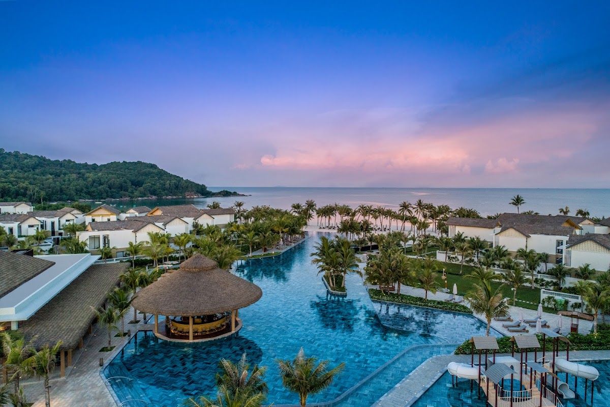 New World Phu Quoc Resort's thatched-roof villas along Khem Beach in the island's south, with turquoise Gulf of Thailand water beyond